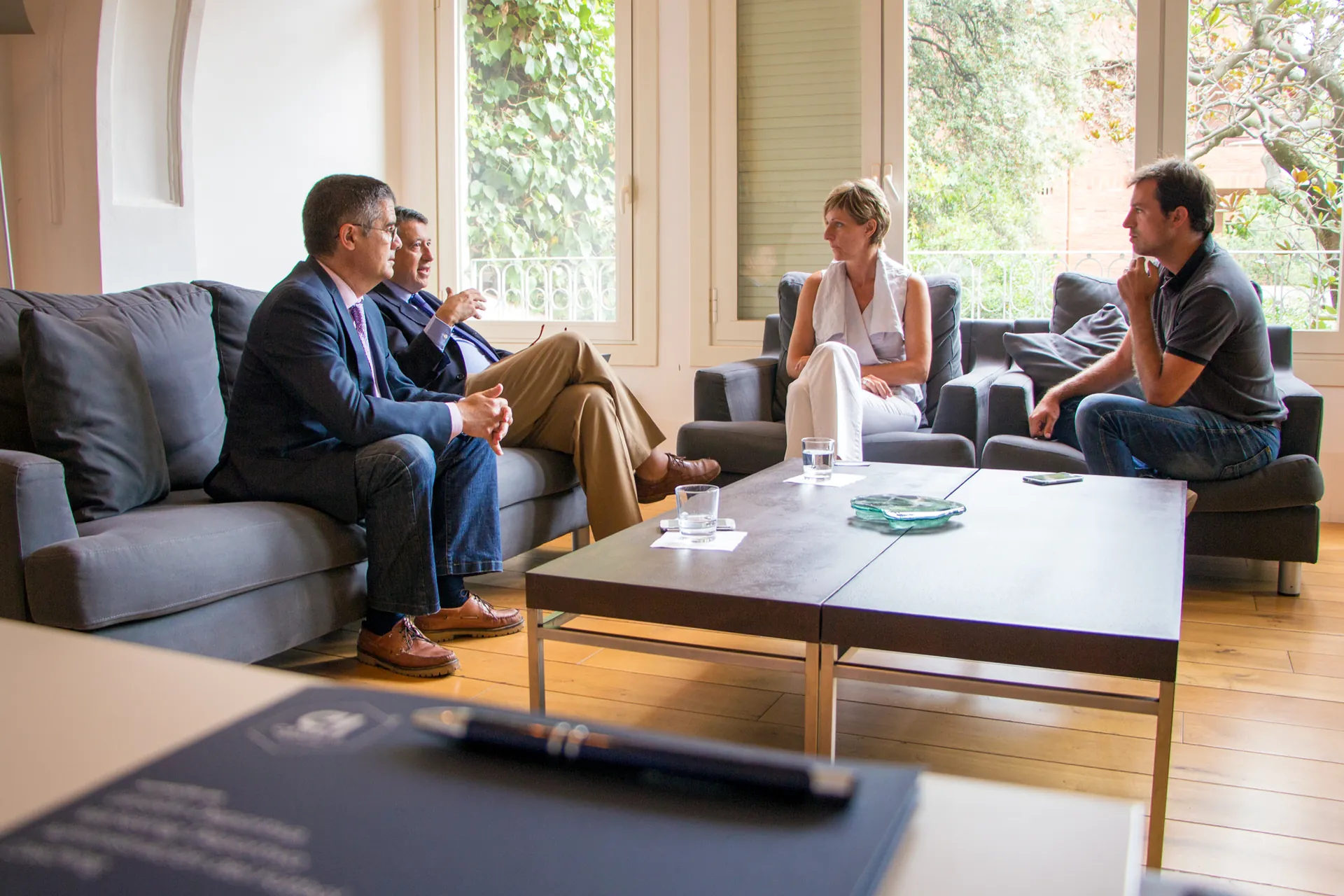 Gesprächsrunde mit vier Personen auf Sofas in einem hellen Raum